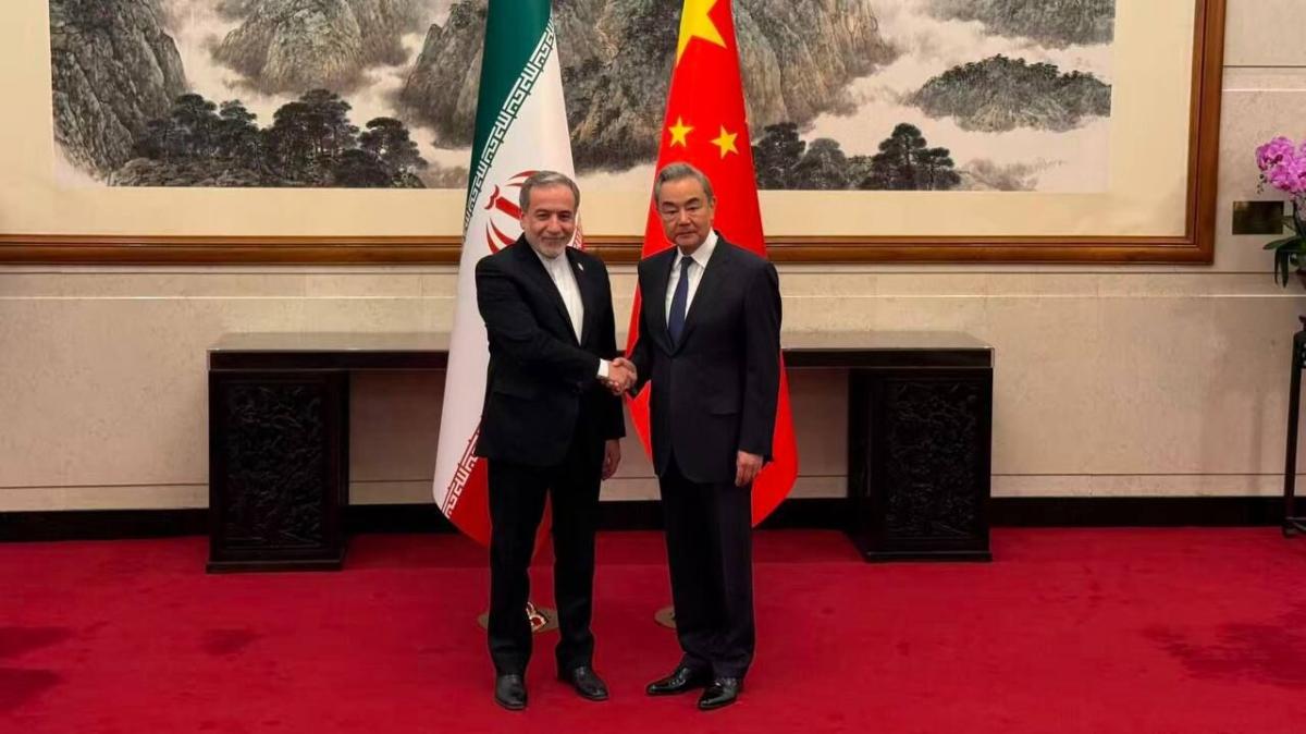 Iran's Foreign Minister Abbas Araghchi shakes hands with his Chinese counterpart Wang Yi